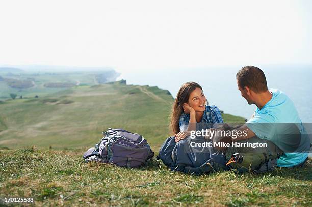 young couple chatting and laughing at the beach - long grass stock pictures, royalty-free photos & images