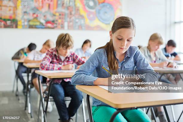 students taking a test in classroom - exam desk stockfoto's en -beelden