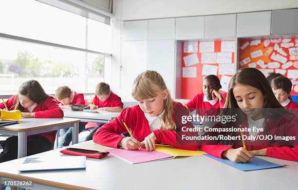 students writing in classroom - school uniform 個照片及圖片檔