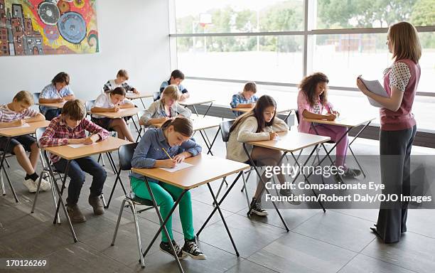 students taking a test in classroom - élève 12 ans photos et images de collection