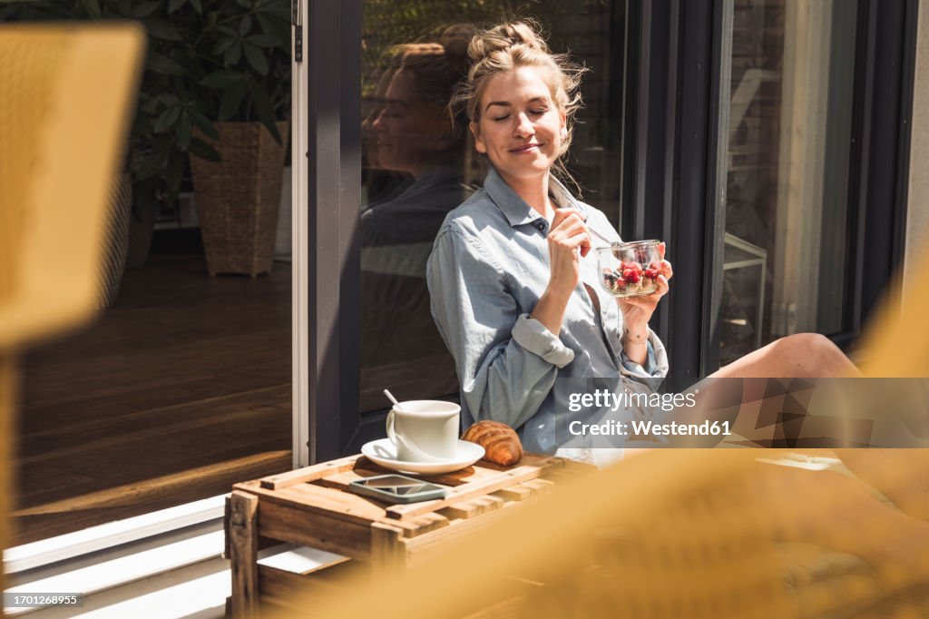 Portrait of a woman enjoying dessert on balcony
