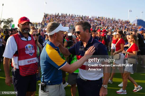 Captain Zach Johnson of Team United States hugs Captain Luke Donald of Team Europe on the 18th hole after Team Europe wins The Ryder Cup at Marco...