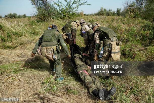 Medics, volunteers and military personnel undergo a tactical training, including first aid and the simulation of a wounded comrade evacuation, in the...