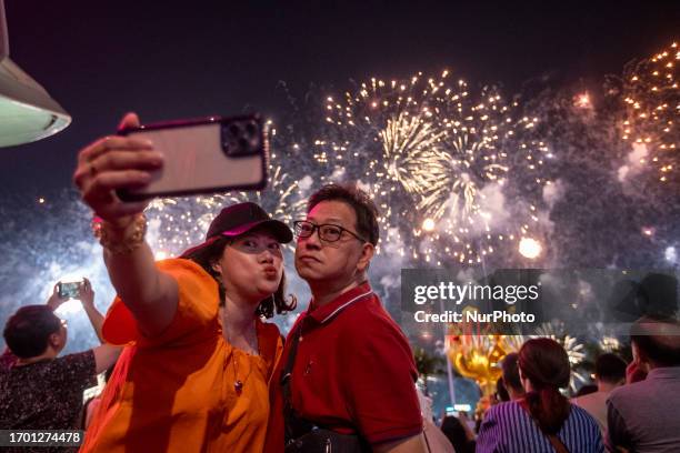 Couple takes a selfie with Fireworks exploding over Victoria Harbour during the China National Day Fireworks Display on October 1, 2023 in Hong Kong,...