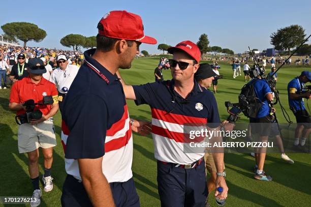 Captain, Zach Johnson consoles US golfer, Scottie Scheffler after his singles match against Europe's Spanish golfer, Jon Rahm on the final day of...