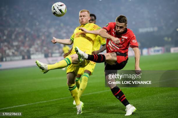 Rennes' French defender Adrien Truffert fights for the ball with Nantes' French midfielder Florent Mollet during the French L1 football match between...