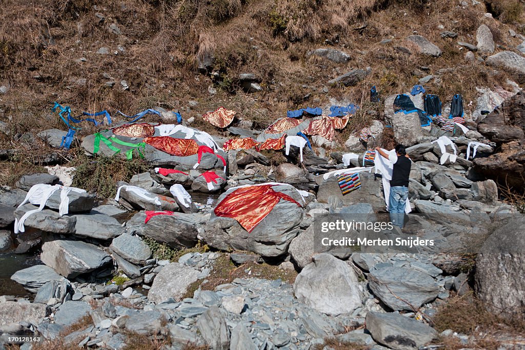 People doing laundry at waterfall