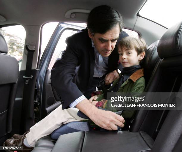 Former French minister and political advisor to Nicolas Sarkozy, Francois Fillon fastens his son Arnaud in a car after voting at a polling station,...