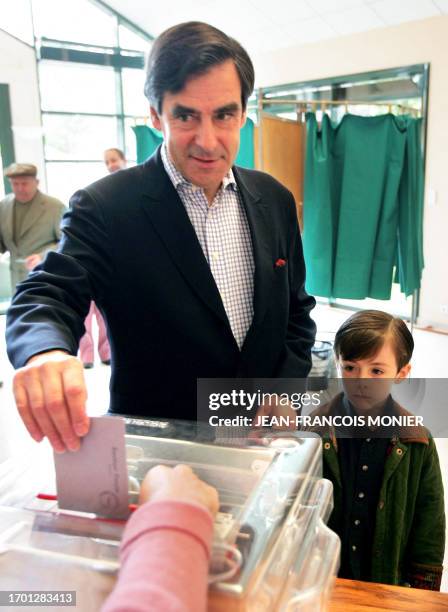 Francois Fillon, former French minister and political advisor to Nicolas Sarkozy, next to his son Arnaud, casts his vote, 06 May 2007, for the second...
