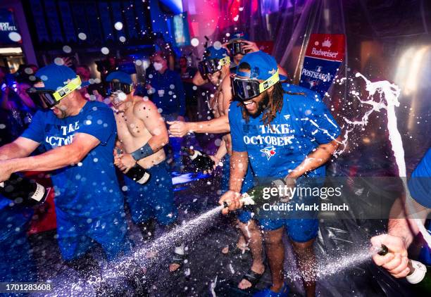 Vladimir Guerrero Jr. #27 of the Toronto Blue Jays sprays champagne in the locker room to celebrate their playoff berth, after the final MLB game of...