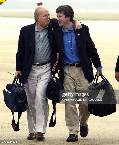 President George W. Bush's Senior Political Advisor Karl Rove walks with his arms around the Assistant to the President and Staff Secretary Brett...