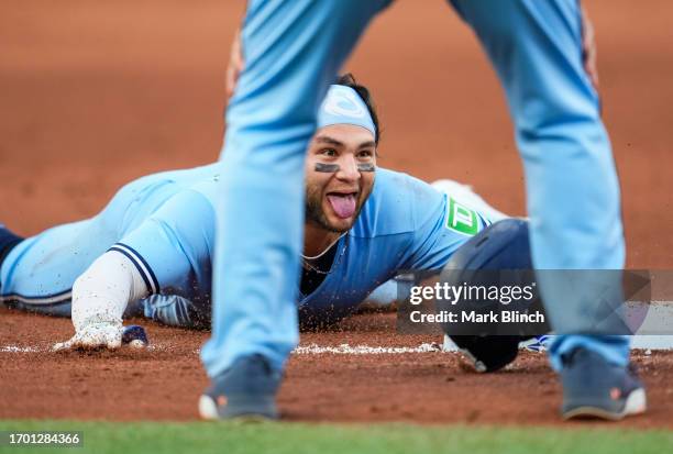 Bo Bichette of the Toronto Blue Jays slides into third base while sticking out his tongue on a triple against the Tampa Bay Rays during the eighth...