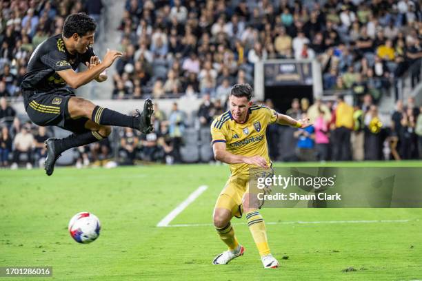 Bryan Oviedo of Real Salt Lake clears the ball as Carlos Vela of Los Angeles FC rushes on during the match at BMO Stadium on October 1, 2023 in Los...