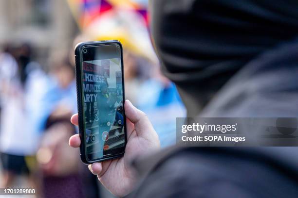 Protester is seen recording a speech by one of the Hong Kong exile Finn Lau during the joint rally. Hongkongers, Southern Mongolian, Tibetan, and the...
