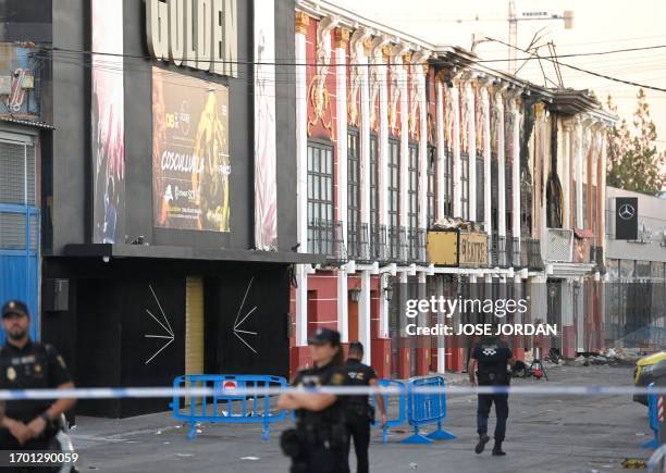 This picture taken on October 2, 2023 shows police officers blocking access after a fire in a nightclub that at least killed thirteen people at a...