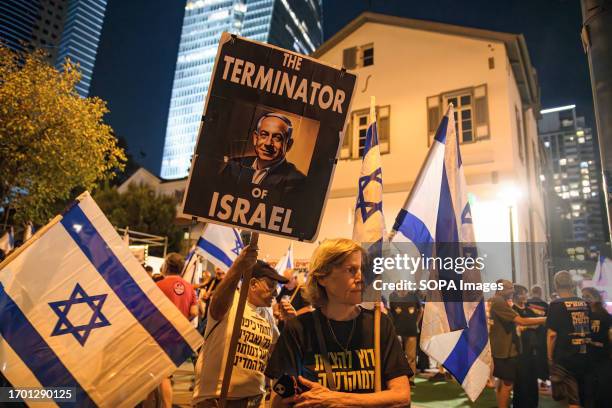 Protester holds a placard with the photo of Prime Minister Benjamin Netanyahu that reads: 'The terminator of Israel' during a demonstration against...