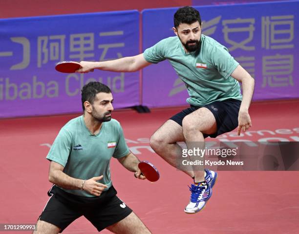 Iranian pair Noshad Alamiyan Daronkolaei and his brother Nima play in the men's table tennis doubles semifinals at the Asian Games in Hangzhou,...