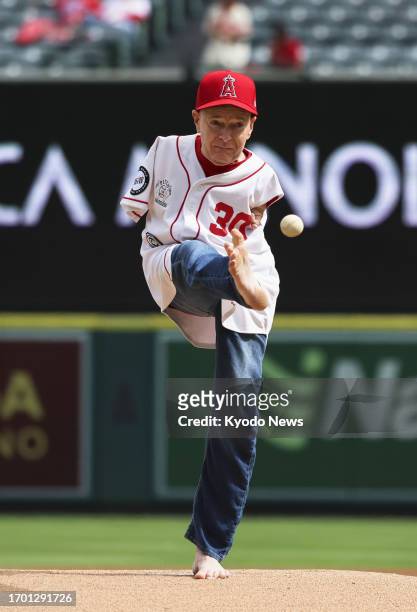 Baseball fan Tom Willis uses his foot for the ceremonial first pitch ahead of a game between the Los Angeles Angels and Oakland Athletics at Angel...