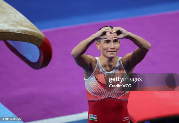 Oksana Chusovitina of Team Uzbekistan forms heart shape with hands during the Artistic Gymnastics - Women's Qualification and Team Final Vault event...