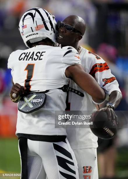 Ja'Marr Chase of the Cincinnati Bengals hugs Former Player Chad Ochocinco Johnson shouts on the sidelines prior to the game between the Los Angeles...