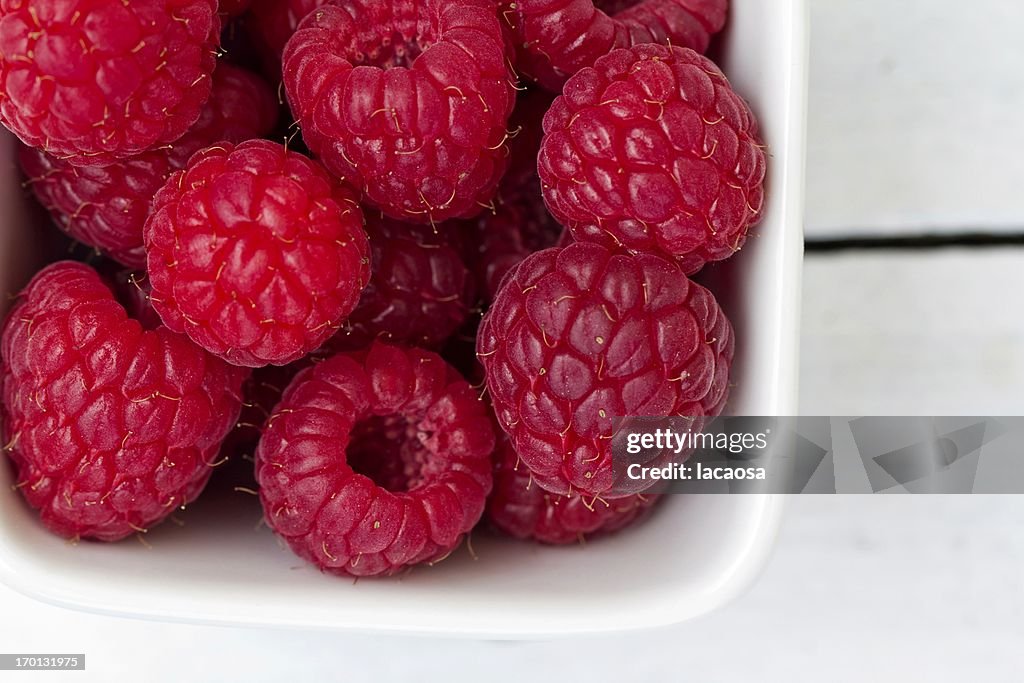 Fresh raspberries in a white bowl