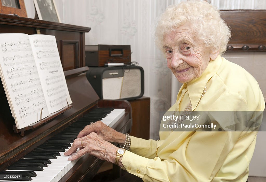 Elderly lady playing piano at home