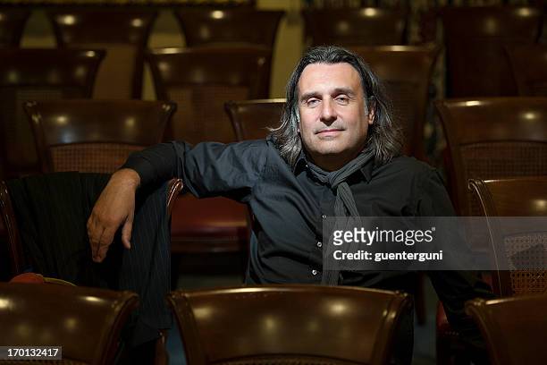 handsome director is sitting in empty auditorium - film director stock pictures, royalty-free photos & images
