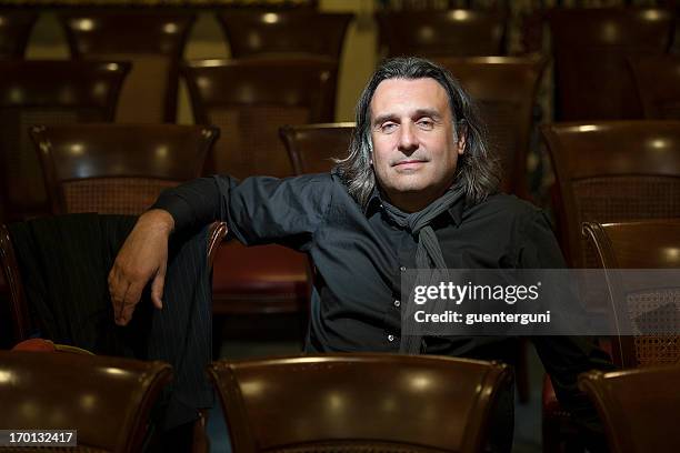 handsome director is sitting in empty auditorium - director chair bildbanksfoton och bilder