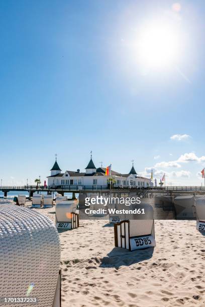 germany, mecklenburg-vorpommern, ahlbeck, sun shining over hooded beach chairs with bathhouse in background - usedom photos et images de collection
