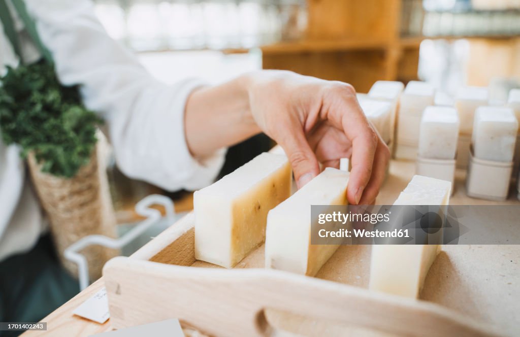 Hand of woman picking scented soap in shop