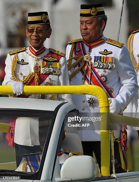 Malaysia's King Abdul Halim Mu'adzam Shah smiles as Chief of Malaysian Armed Forces Zulkifeli Mohd Zin looks on after inspecting a guard of honour...