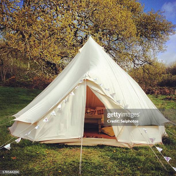 bell tent with bunting. glamping in devon.. - camping de lujo fotografías e imágenes de stock