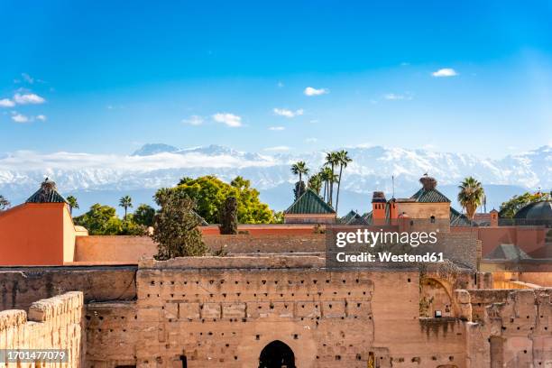 morocco, marrakesh-safi, marrakesh, walls of el badi palace with mountains in background - marokko marrakesh stock-fotos und bilder