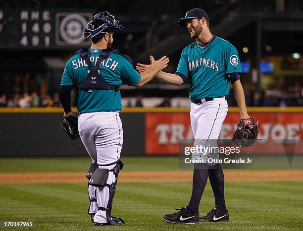 Closing pitcher Tom Wilhelmsen of the Seattle Mariners celebrates with catcher Kelly Shoppach after defeating the New York Yankees 4-1 at Safeco...