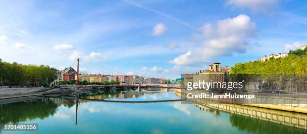 lyon, france: modern pedestrian bridge over the saône, riverside cityscape - emerald city stockfoto's en -beelden