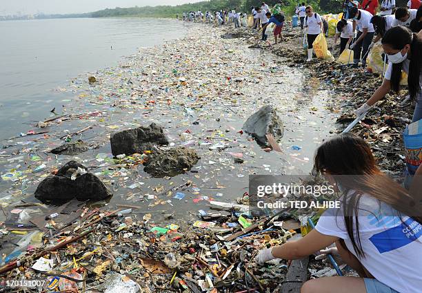 Volunteers remove rubbish washed ashore along the coastline of freedom island in Paranaque City, suburban Manila on June 8, 2013 during a coastal...