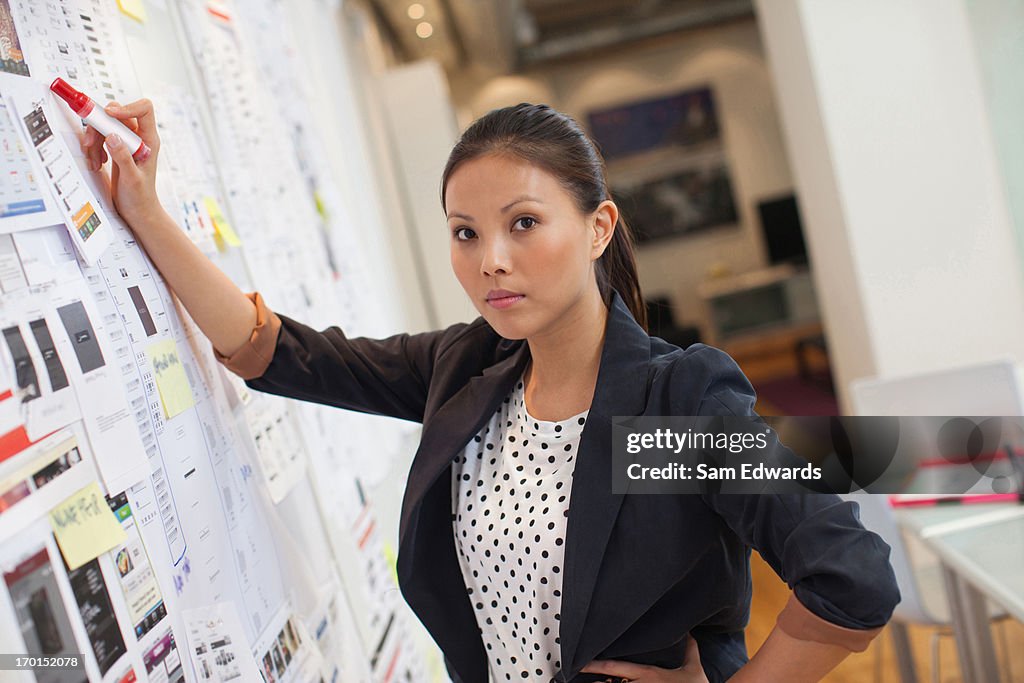  Businesswoman front of whiteboard in office