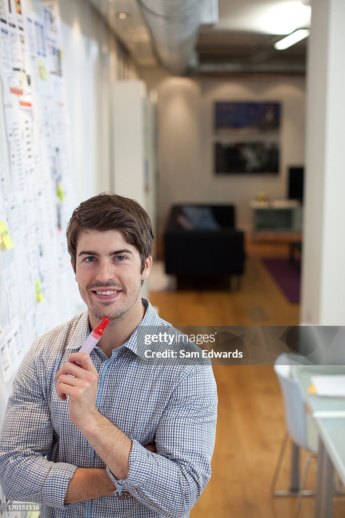 Portrait of smiling businessman at whiteboard in office
