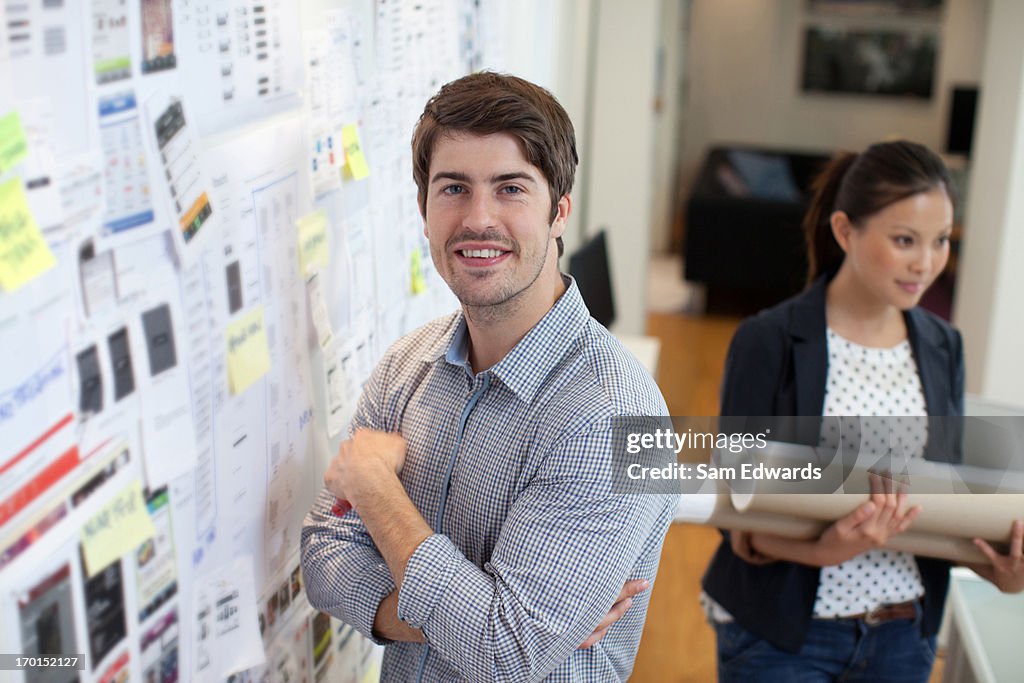 Retrato de hombre de negocios sonriendo en oficina en pizarra acrílica