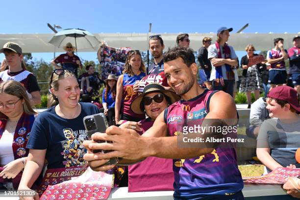 Callum Ah Chee of the Lions takes selfies with fans during a Brisbane Lions AFL training session at Brighton Homes Arena on September 26, 2023 in...