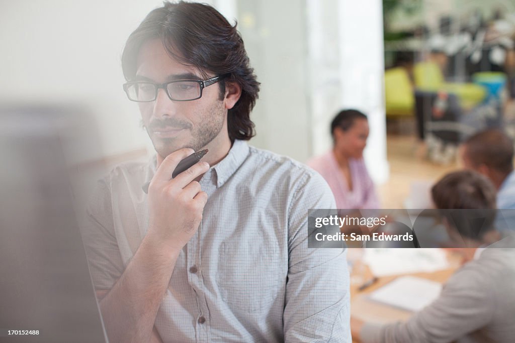 Pensive businessman looking at chart in meeting
