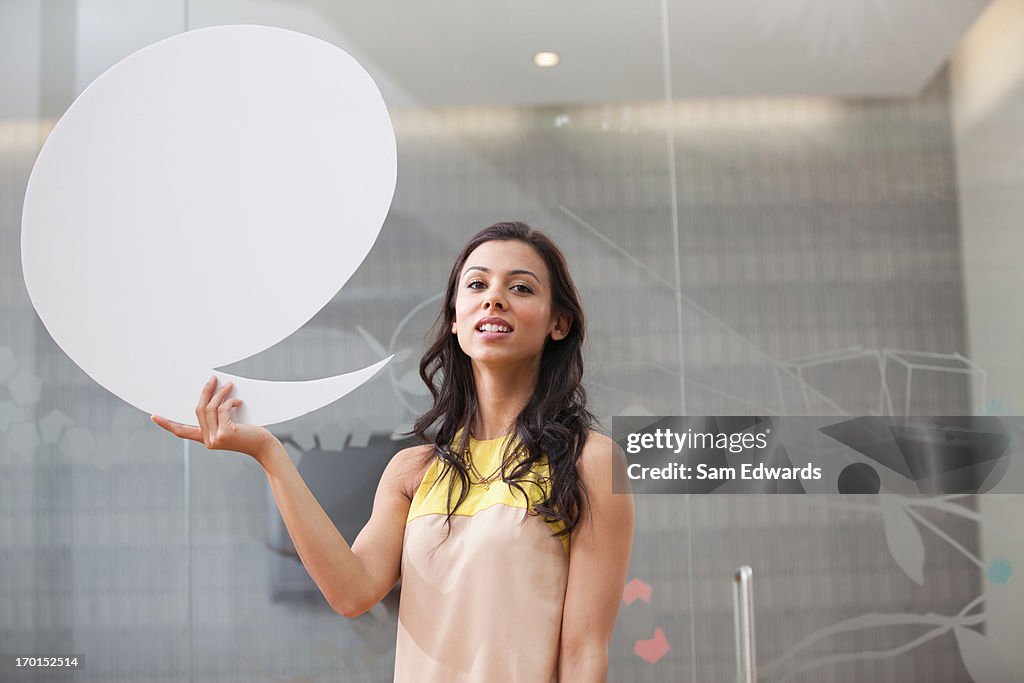 Portrait of smiling businesswoman holding speech bubble