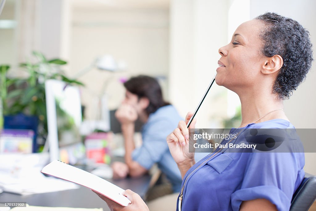 Close up of smiling businesswoman looking up in office