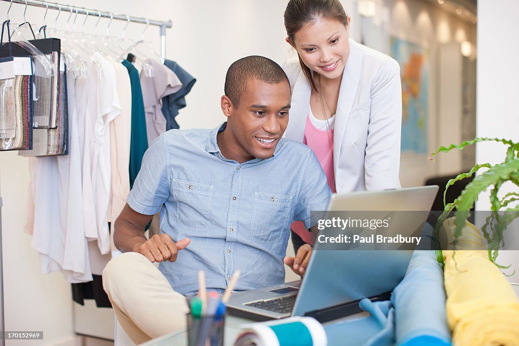 Fashion designers using laptop in office