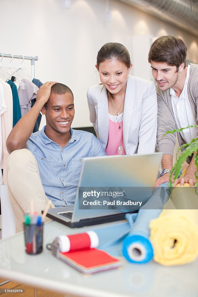 Fashion designers using laptop in office