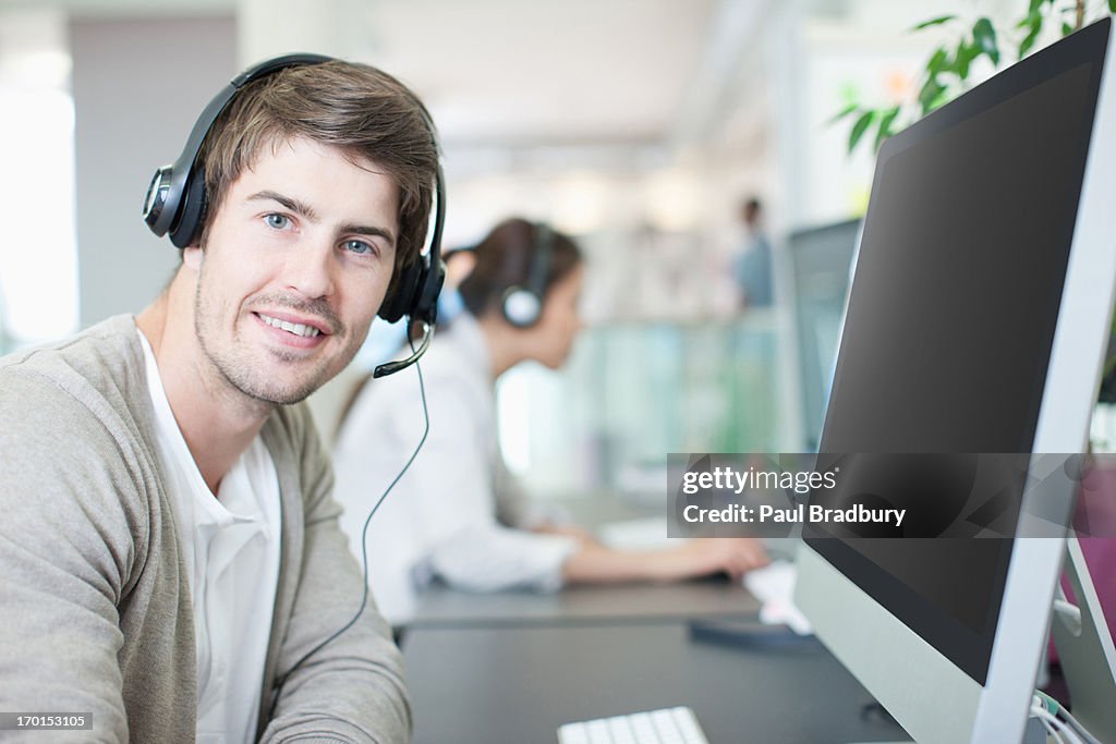 Uomo d'affari con auricolare lavorando al computer in ufficio