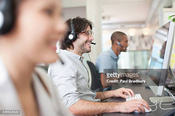 business people with headsets working at computers in office - assistance stockfoto's en -beelden