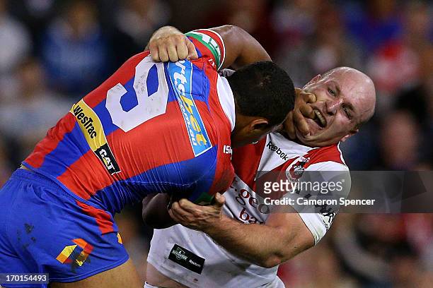 Travis Waddell of the Knights is tackled by Michael Weyman of the Dragons during the round 13 NRL match between the Newcastle Knights and the St...