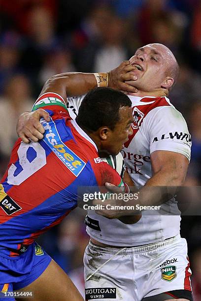 Travis Waddell of the Knights is tackled by Michael Weyman of the Dragons during the round 13 NRL match between the Newcastle Knights and the St...