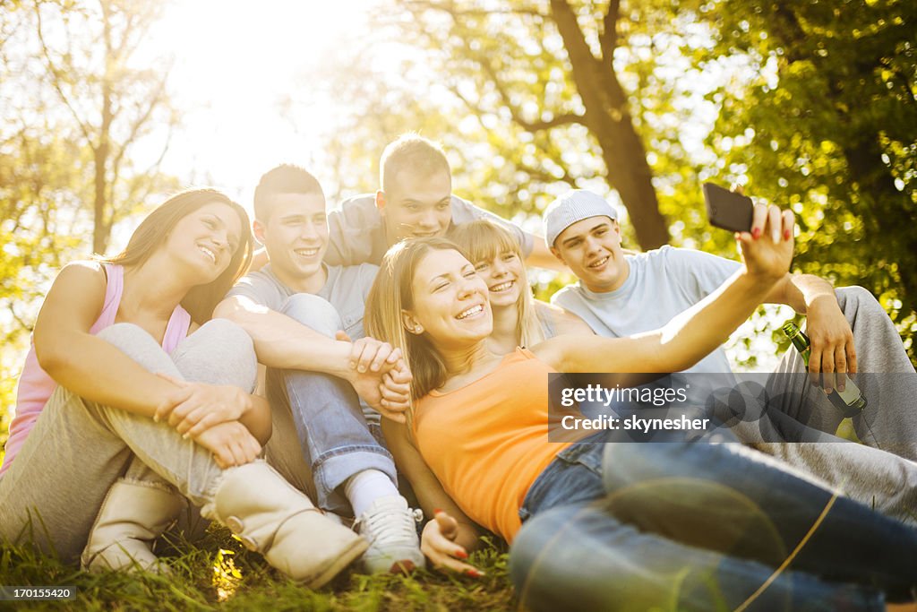 Teenagers taking a photo of themselves in park.